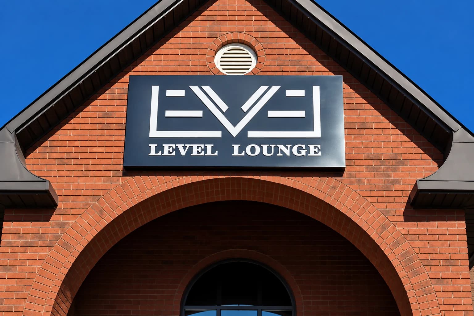 Retouched detail of the Level Lounge sign and brick facade from campaign footage
