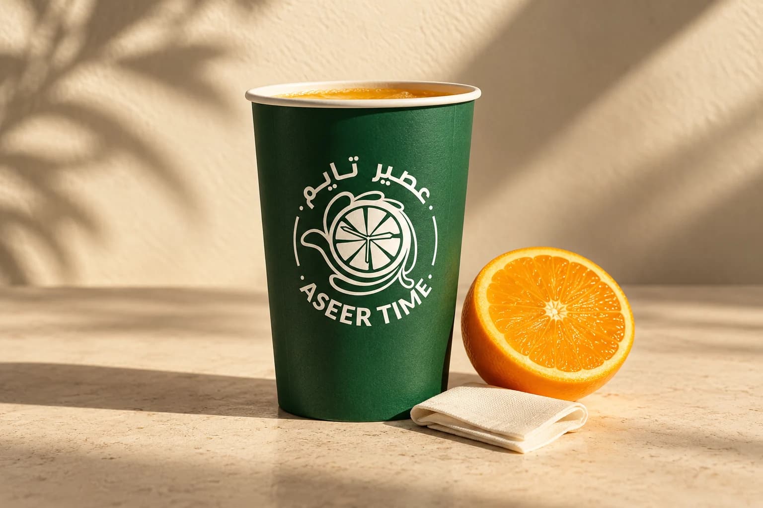 Aseer Time portfolio artwork with its logo on a green cup beside fresh citrus