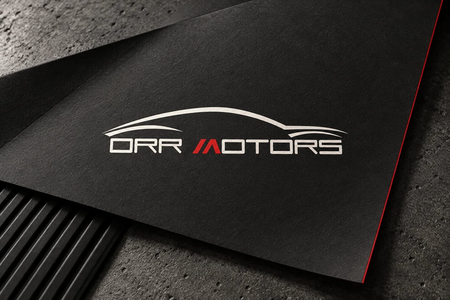 Orr Motors portfolio artwork with its white and red wordmark on charcoal paper