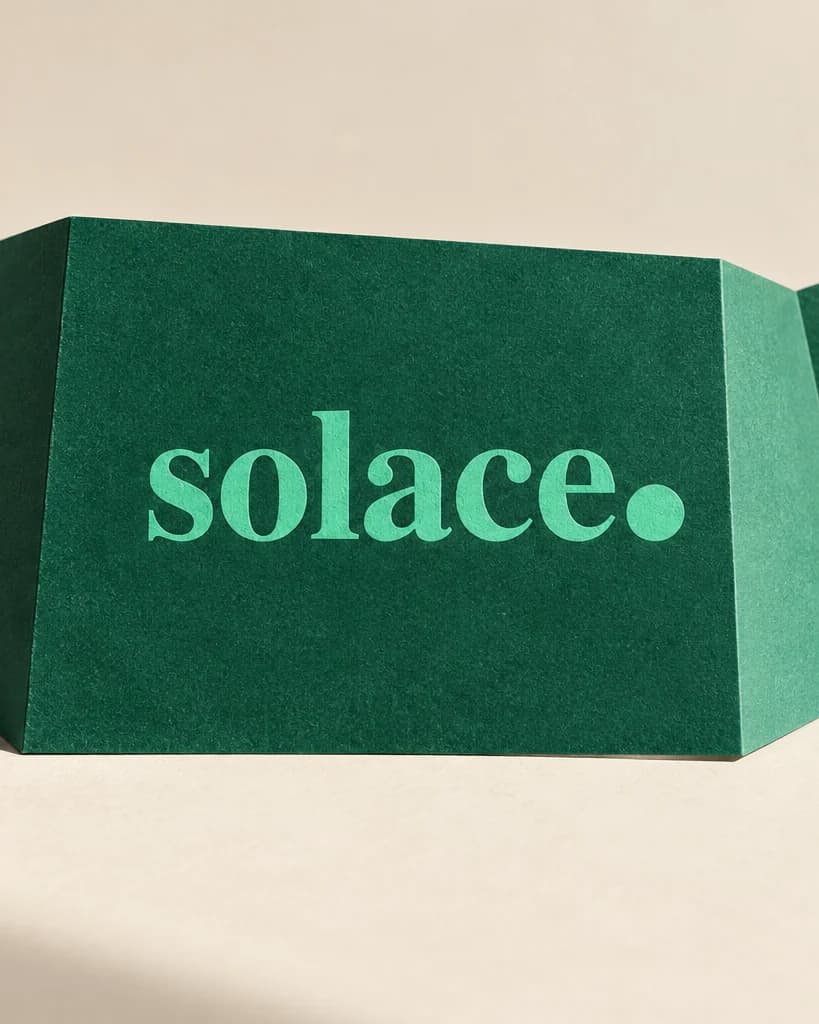 Solace portfolio artwork with its mint wordmark on folded emerald paper