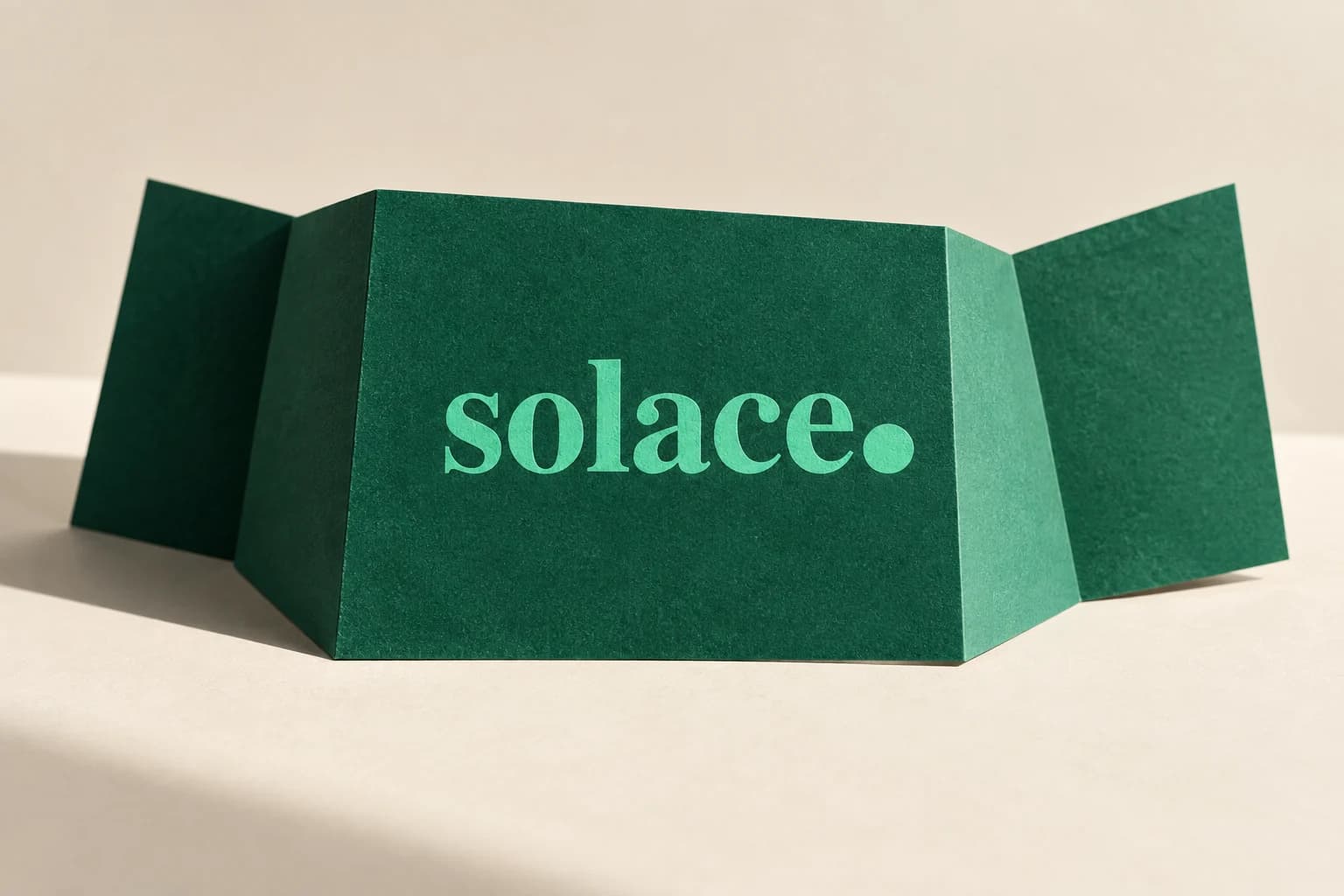 Solace portfolio artwork with its mint wordmark on folded emerald paper